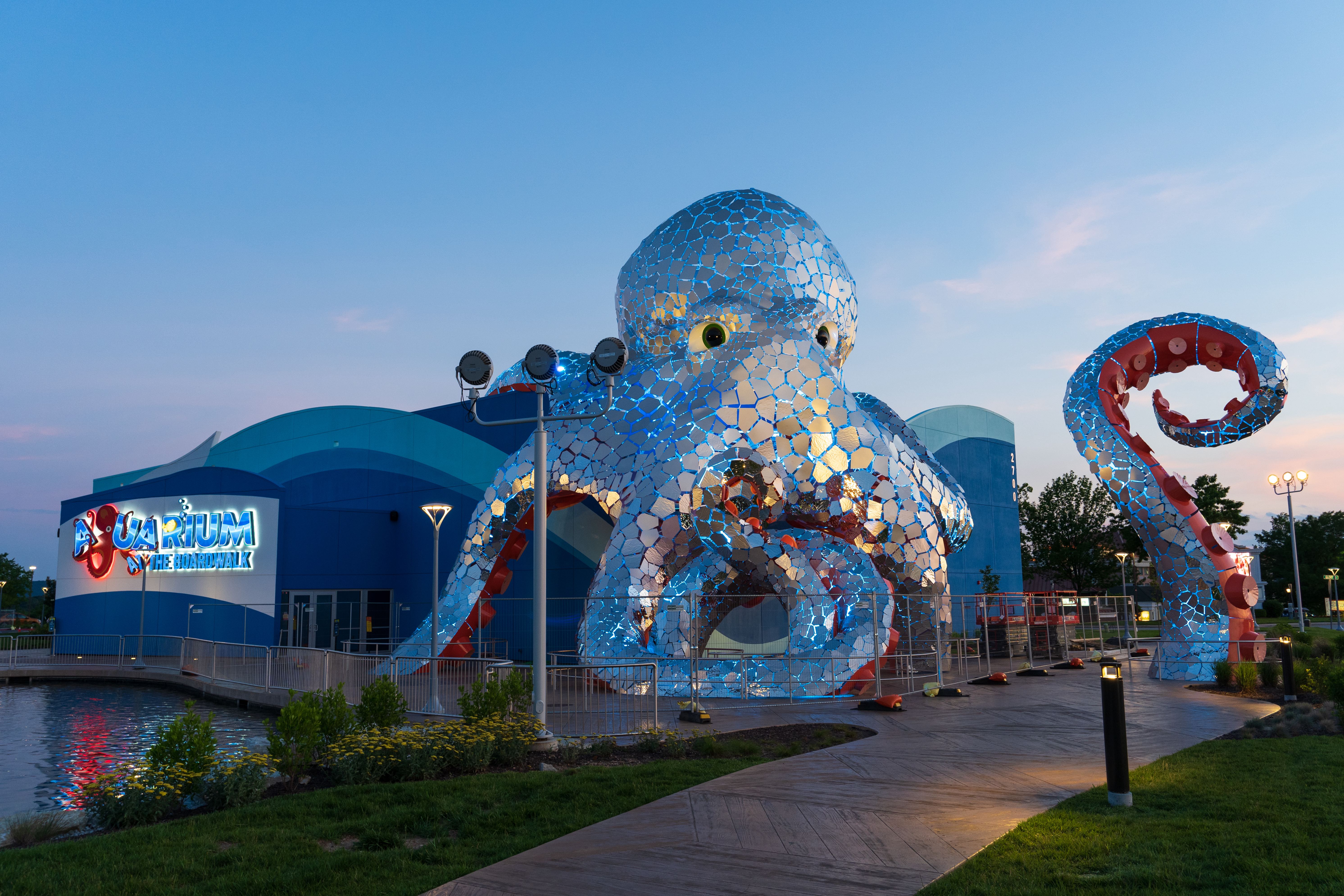 Aquarium at the Branson boardwalk at dusk with the lights on the giant octopus covering the building.