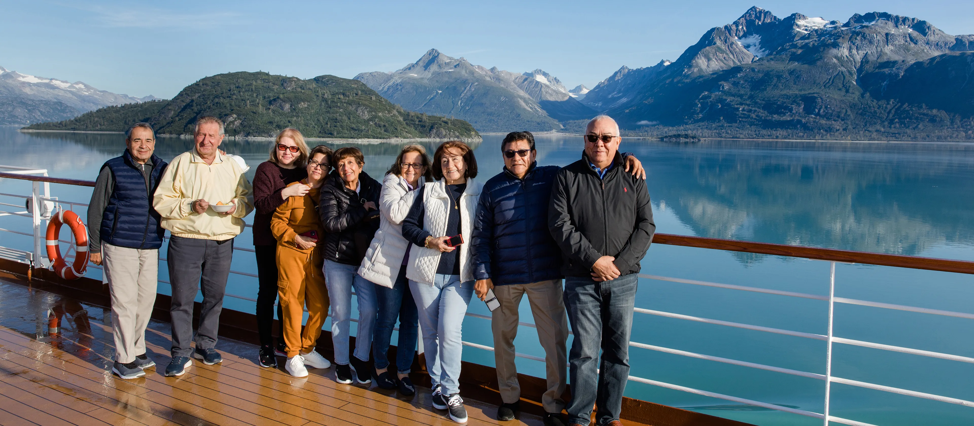 Group of travelers standing together on the deck of a cruise ship