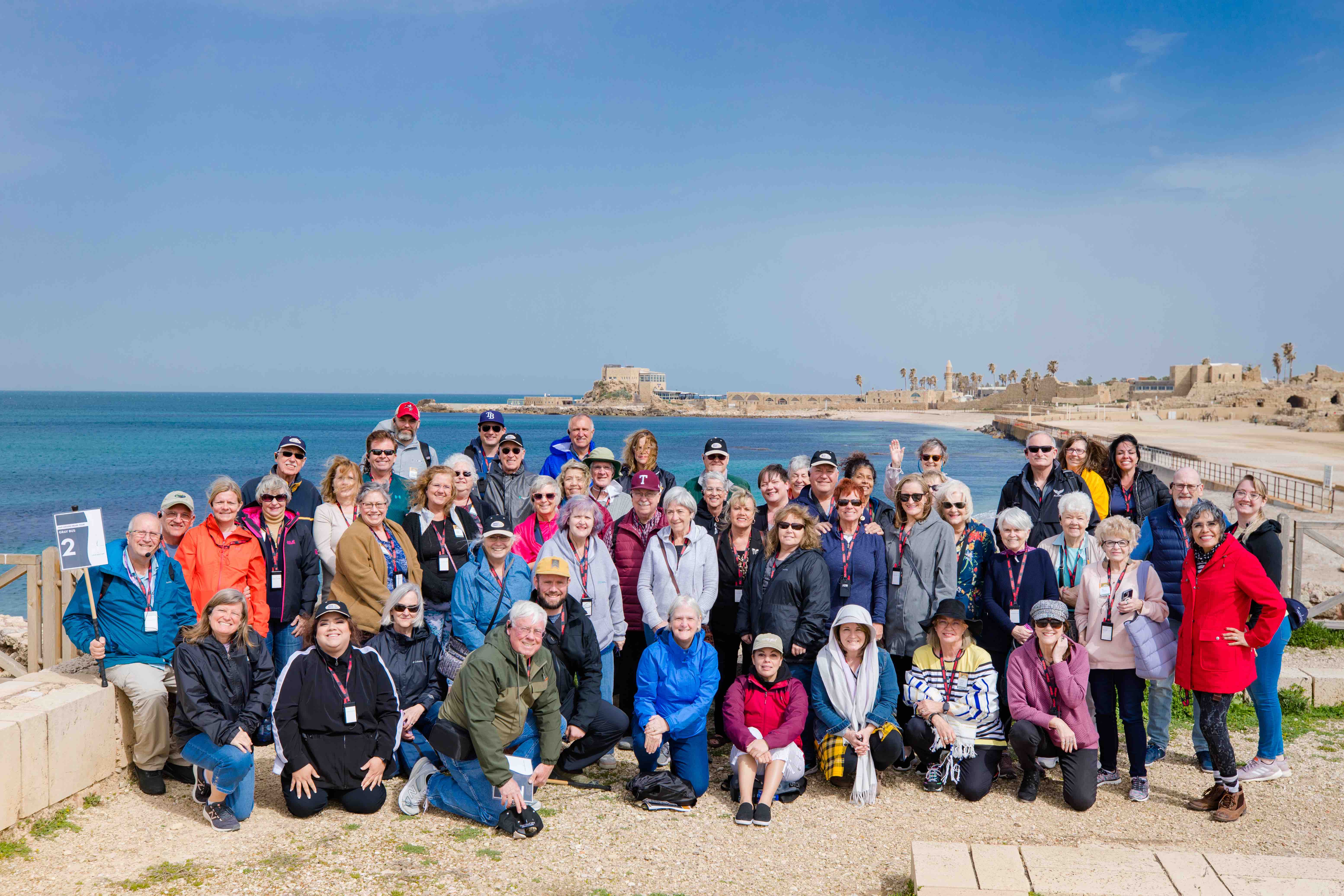 Inspiration travelers gathered together for a group picture in Caesarea Maritima on the coast of the Mediterranean Sea