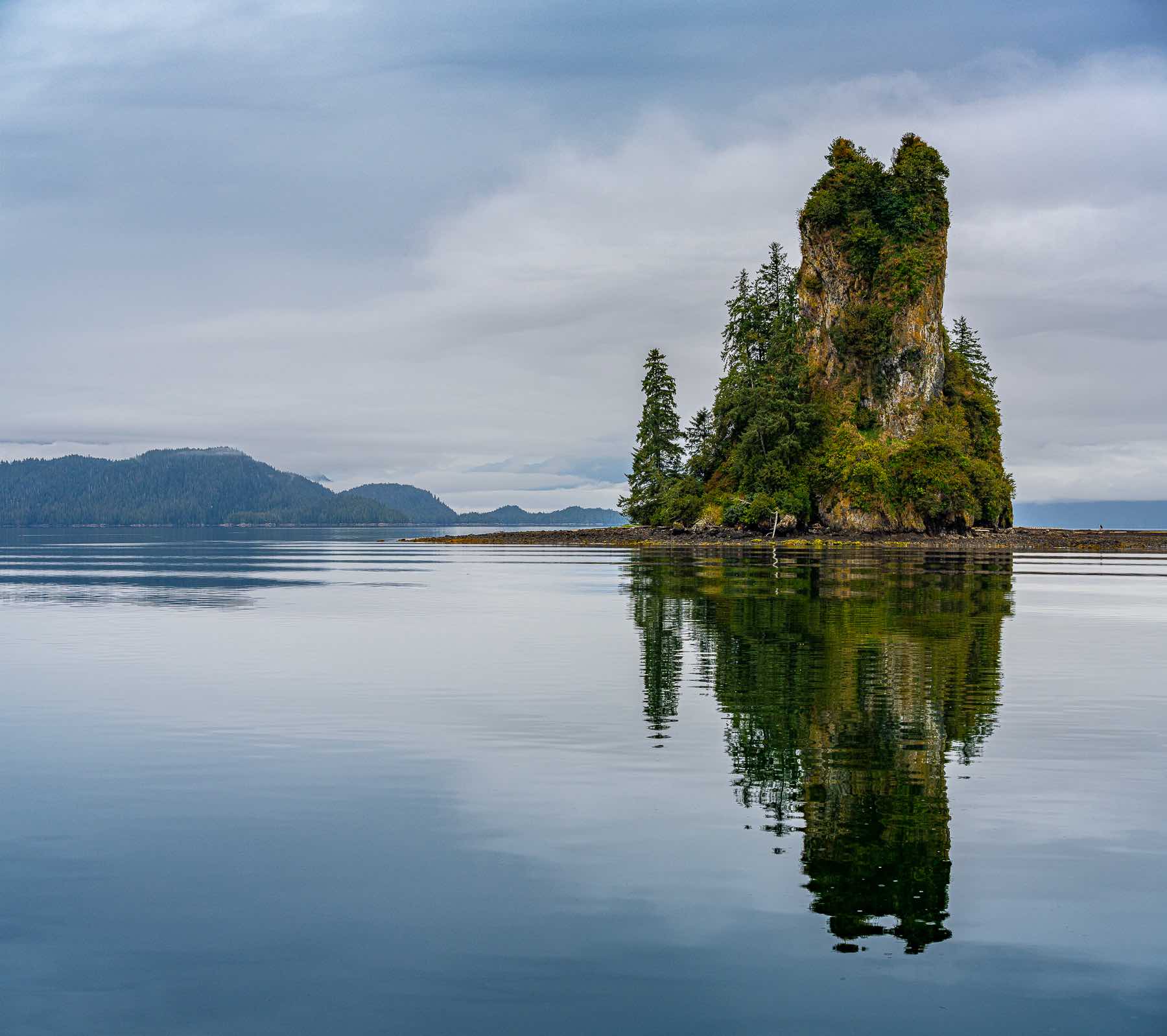 The New Eddystone Rock jutting from a small island wrapped inside a bay in the Misty Fjords.