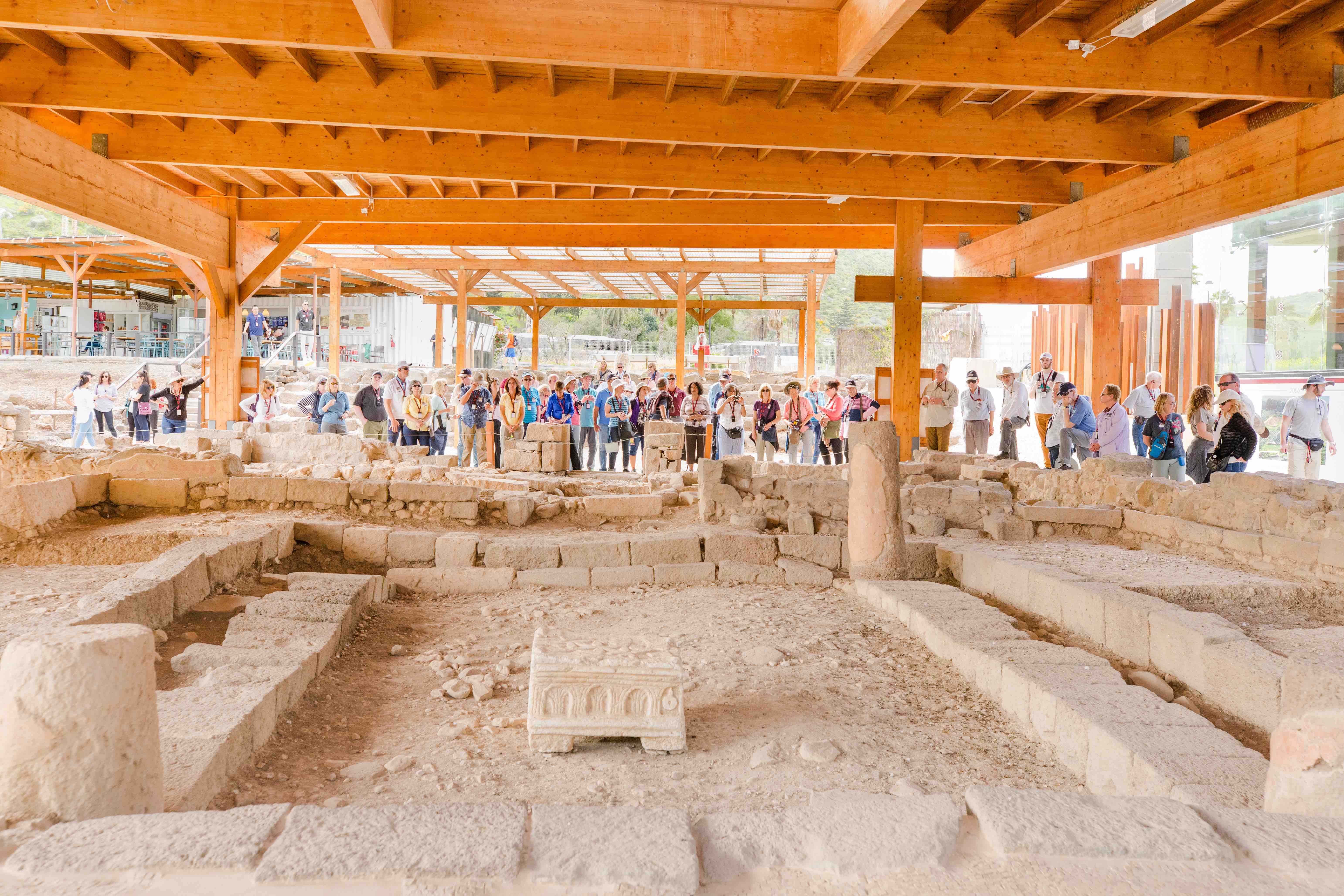 Group of people touring a first-century synagogue site in Magdala.