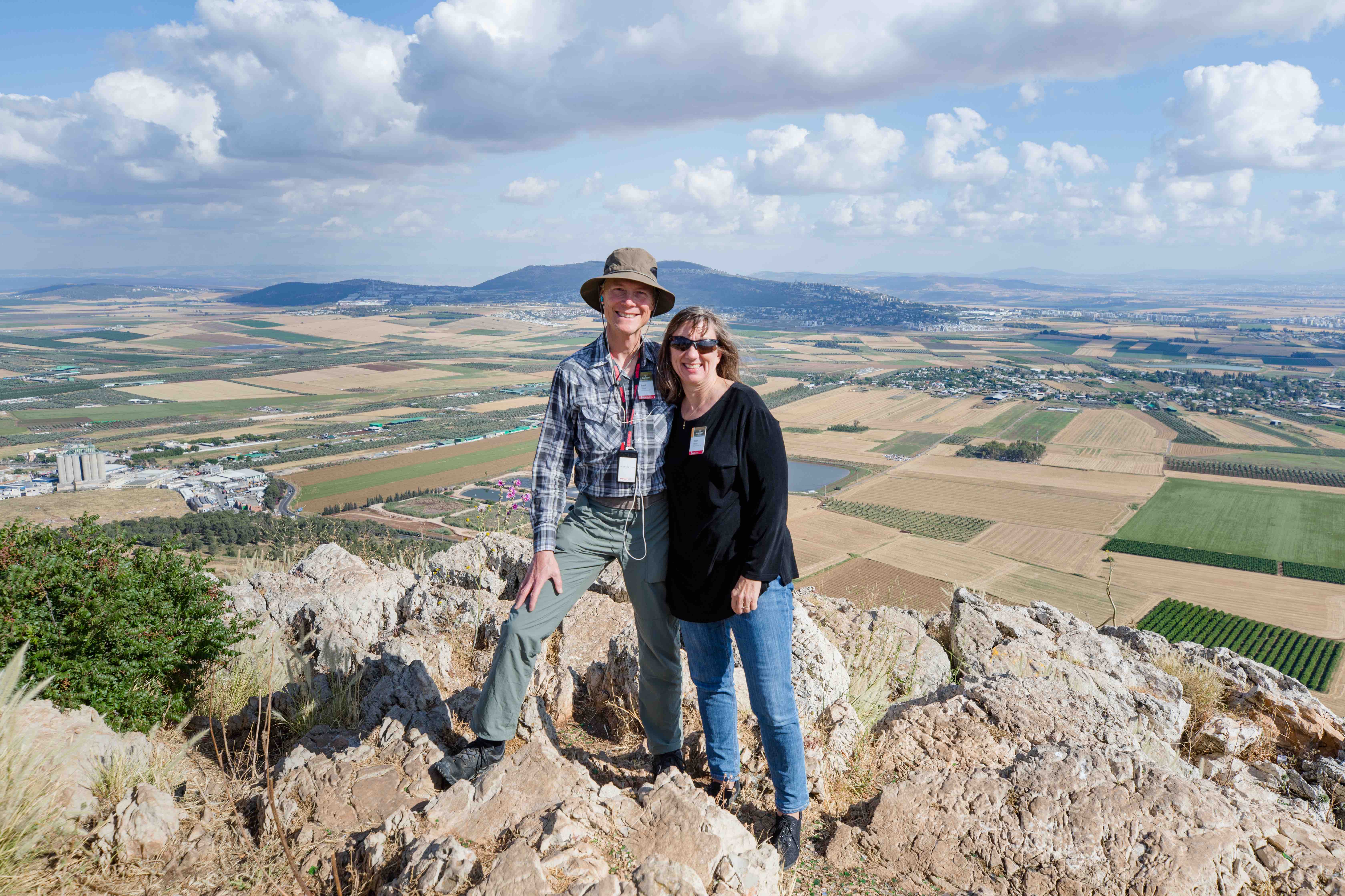 Two travelers standing together with Jezreel Valley in the background