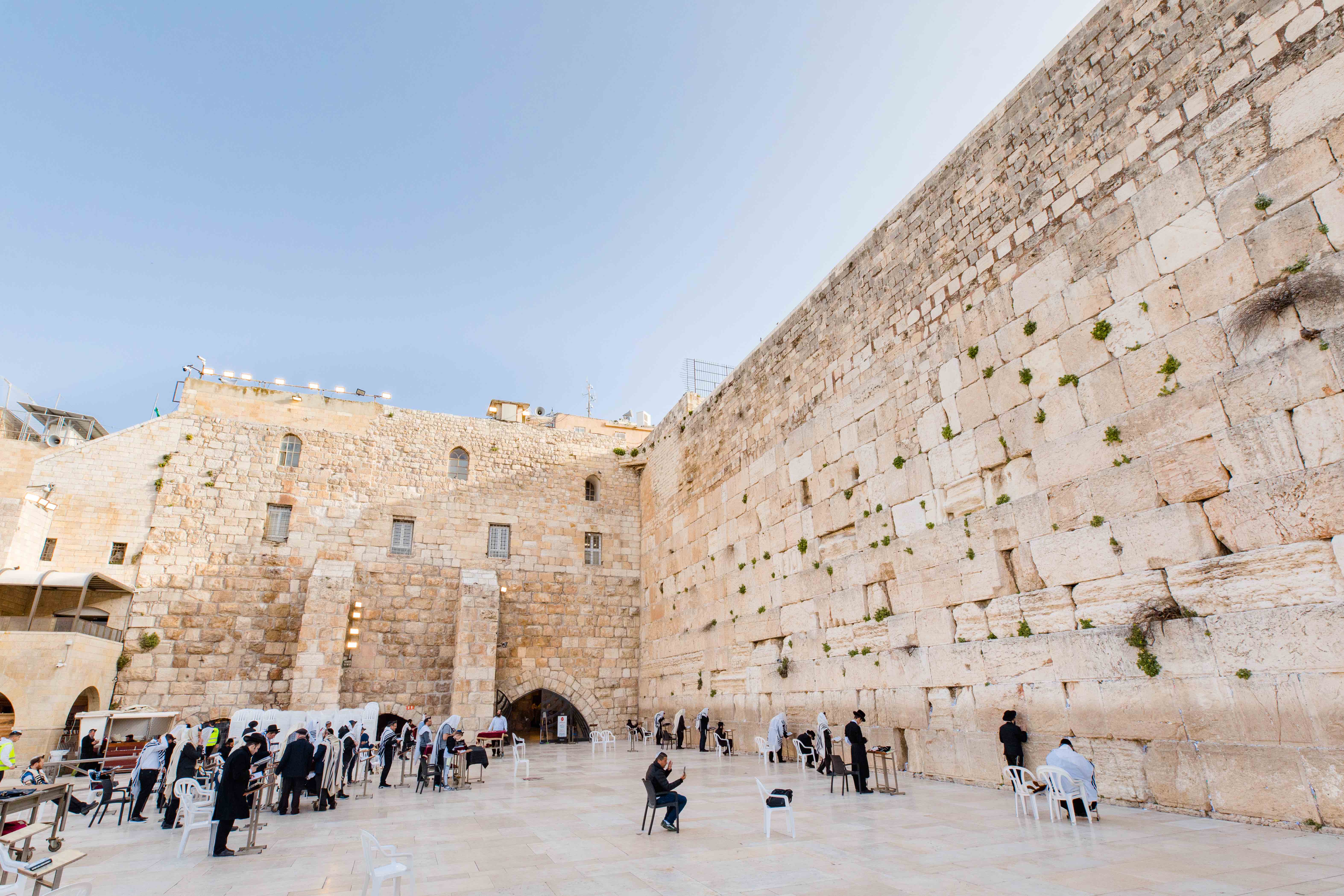 Travelers alongside locals pray at the iconic Western Wall