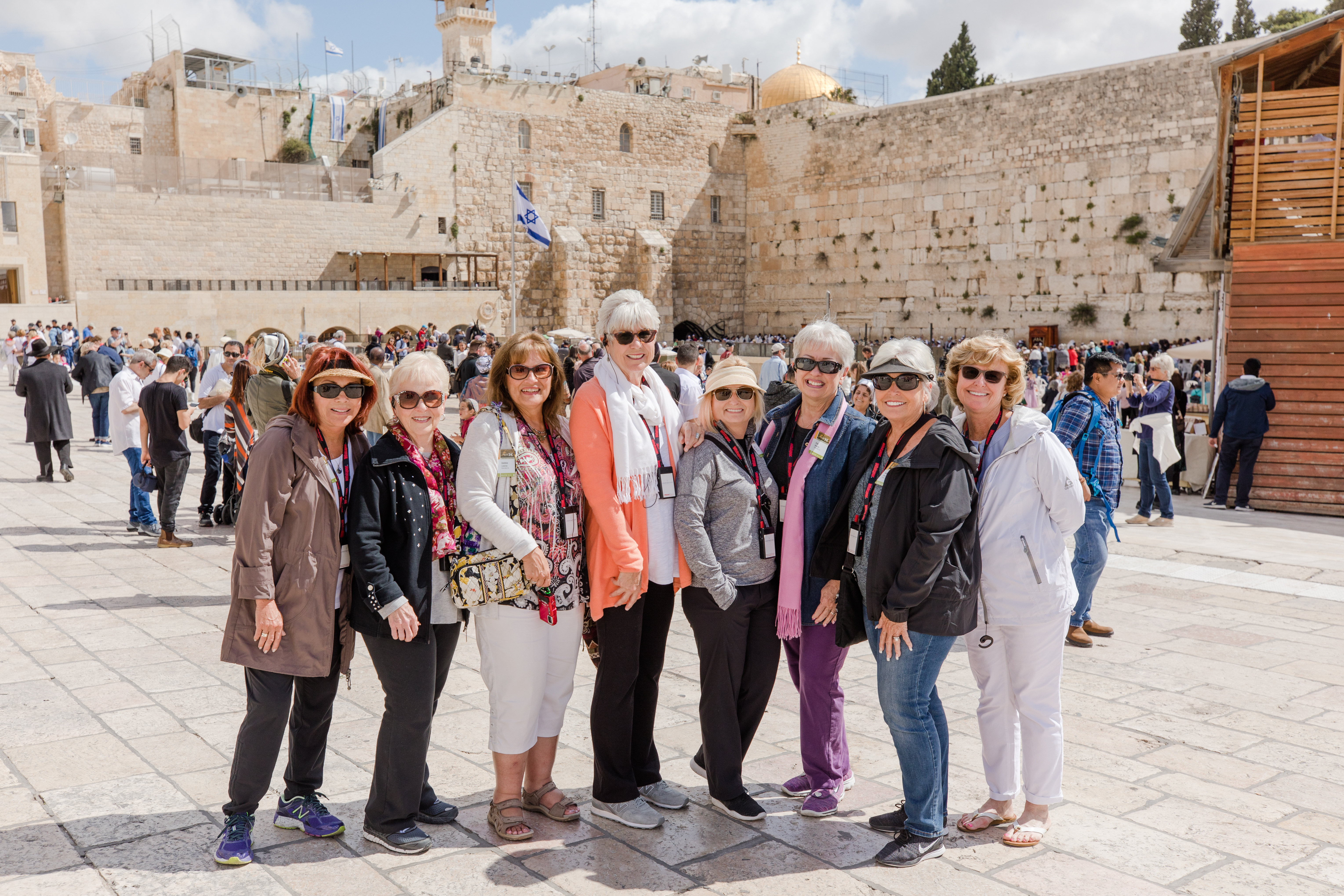 A group of female travelers smile near the Western Wall